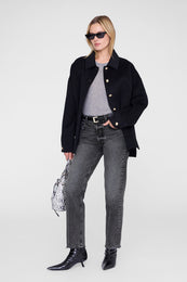 Grey crew neck t-shirt worn under a black blazer with gold buttons.